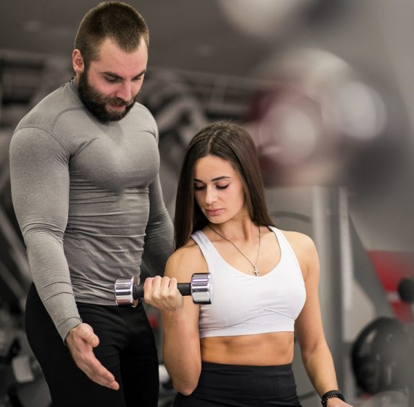 Woman at gym with coach